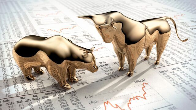 bull and bear figurines placed on a financial newspaper