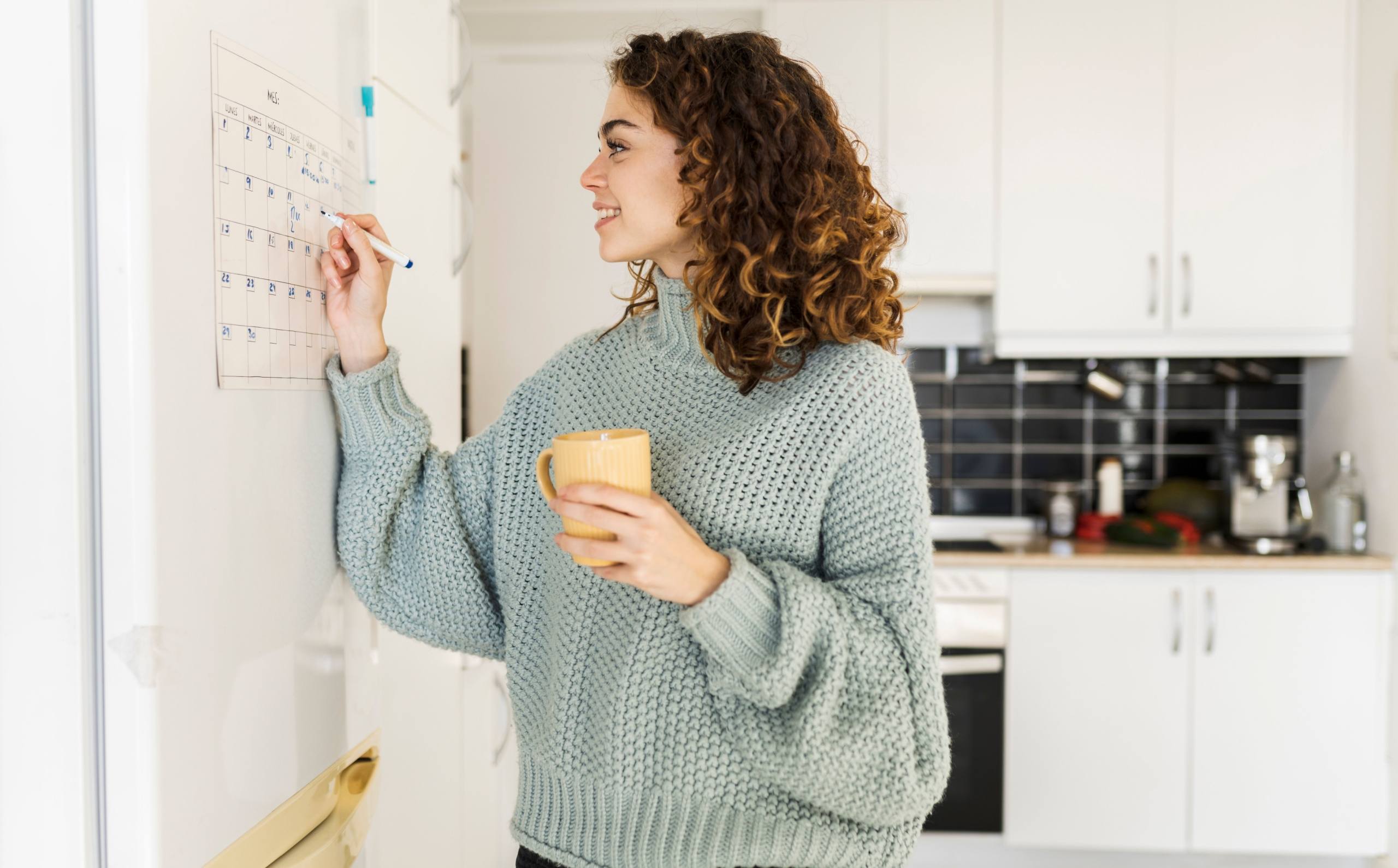 A woman marking her calendar.