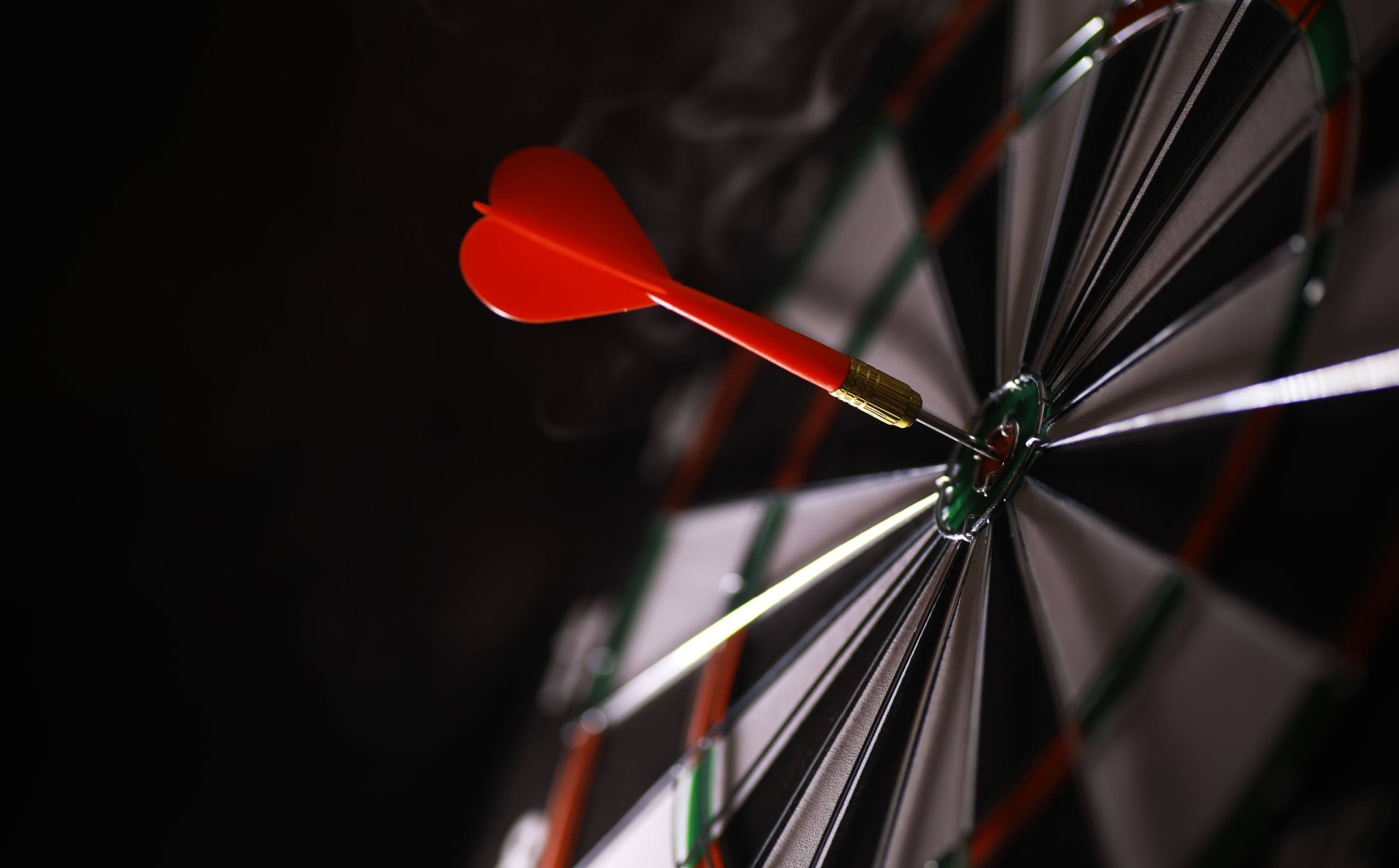 dart hitting bullseye on dart board